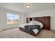 A bedroom featuring a large window, neutral-toned carpet, and a decorative headboard with matching side chests at 20826 Robins Dr, Denver, CO 80249