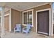 Cozy covered porch with two blue chairs, perfect for relaxing outdoors at 20826 Robins Dr, Denver, CO 80249