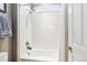 White tiled shower/tub combination is brightened by a transom window at 12740 W 73Rd Pl, Arvada, CO 80005