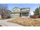 Traditional two-story home features green siding, a welcoming front porch, and a two-car garage at 3137 E 112Th Pl, Thornton, CO 80233