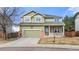 Charming two-story home with green siding, brick accents, and a covered front porch at 3137 E 112Th Pl, Thornton, CO 80233