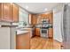Well-lit kitchen featuring wood cabinets, stainless steel appliances, and a window overlooking the yard at 3137 E 112Th Pl, Thornton, CO 80233