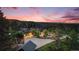 Expansive property featuring a luxurious home, surrounded by lush greenery and picturesque mountain views at sunset at 12555 Critchell Ln, Littleton, CO 80127