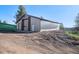 Spacious barn with multiple roll-up doors, providing ample storage and utility space on a level ground at 12555 Critchell Ln, Littleton, CO 80127