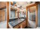 Stylish bathroom with natural wood accents, dual mirrors, and stone countertops at 12555 Critchell Ln, Littleton, CO 80127