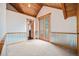 Bedroom with wood-paneled vaulted ceilings and deck access through glass paneled doors at 12555 Critchell Ln, Littleton, CO 80127