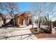 Inviting home entrance featuring a timber-framed porch, stone accents, and a well-maintained walkway at 12555 Critchell Ln, Littleton, CO 80127