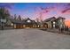 Expansive multi-level house with a basketball hoop, large garage, and scenic mountain views during a colorful sunset at 12555 Critchell Ln, Littleton, CO 80127