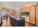 The kitchen includes a center island and is adjacent to a stone archway leading to the dining room at 12555 Critchell Ln, Littleton, CO 80127