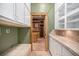 Hallway featuring laundry room, custom shelving, and views of the walk-in closet at 12555 Critchell Ln, Littleton, CO 80127