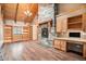 Living room showcasing a stone fireplace, hardwood floors, custom built-in shelving, and natural light at 12555 Critchell Ln, Littleton, CO 80127