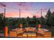 Expansive outdoor patio featuring comfortable seating under romantic string lights with a spectacular sunset at 12555 Critchell Ln, Littleton, CO 80127