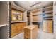Custom walk-in closet with lots of shelving and drawers in natural wood at 12555 Critchell Ln, Littleton, CO 80127