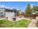 Backyard featuring a patio with dining and fire pit, a wooden fence, and a small lawn at 3764 N Raleigh St, Denver, CO 80212