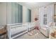 Bright Bedroom with two cribs, chair, striped wall, and natural light at 3764 N Raleigh St, Denver, CO 80212