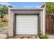 Exterior shot of the garage featuring a white garage door and painted trim in a fenced backyard at 3764 N Raleigh St, Denver, CO 80212