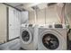 Bright Laundry room featuring two modern front load washing machines and a white door at 3764 N Raleigh St, Denver, CO 80212