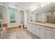 Updated bathroom with double sinks, granite countertops, travertine tile floors, walk-in shower, and soaking tub at 2400 E Cherry Creek South Dr # 207, Denver, CO 80209