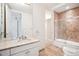 Tiled bathroom features marble countertop, sink, and glass-door shower at 2400 E Cherry Creek South Dr # 207, Denver, CO 80209