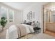 Bright bedroom with contemporary decor, large windows, and a view into the en suite bathroom at 2400 E Cherry Creek South Dr # 207, Denver, CO 80209