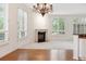 Bright living room with a decorative fireplace, large windows, light-colored carpet and dark-stained hardwood flooring at 2400 E Cherry Creek South Dr # 207, Denver, CO 80209