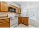 Well-lit kitchen with white range and microwave open to the living area at 18287 E Floyd Ave # L, Aurora, CO 80013