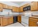 Classic kitchen featuring wood cabinets, white appliances, and a functional layout at 18287 E Floyd Ave # L, Aurora, CO 80013