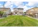 Spacious backyard with green lawn, patio with seating, trampoline, and privacy fence at 4884 St Vrain Rd, Firestone, CO 80504