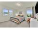 Bedroom with carpet, large windows, colorful bedspread and a side table and lamp at 4884 St Vrain Rd, Firestone, CO 80504