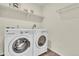 Laundry room with front-loading washer and dryer and overhead shelving at 4884 St Vrain Rd, Firestone, CO 80504