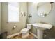 A half-bathroom features a toilet, sink, round mirror and earth tone paint at 2447 Fairway Wood Cir, Castle Rock, CO 80109