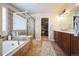A relaxing main bathroom features dual vanities, soaking tub and glass-enclosed shower, and walk-in closet at 2447 Fairway Wood Cir, Castle Rock, CO 80109