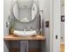 Stylish powder room features a vessel sink on a rustic wooden counter and a round mirror at 1582 W Briarwood Ave, Littleton, CO 80120