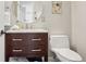 Stylish bathroom features a wood vanity with marble countertop, round mirror and modern toilet at 1582 W Briarwood Ave, Littleton, CO 80120