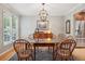 Elegant dining room featuring hardwood floors, stylish lighting fixture, and classic wood furniture at 1582 W Briarwood Ave, Littleton, CO 80120
