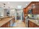 Galley style kitchen with stainless appliances, wood cabinets, granite countertops and a skylight at 1582 W Briarwood Ave, Littleton, CO 80120