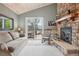 Cozy living room with a stone fireplace, sliding glass door, and vaulted ceiling with a wooden finish at 1582 W Briarwood Ave, Littleton, CO 80120