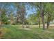 A lush green lawn, mature trees, and natural setting with vibrant foliage at 1582 W Briarwood Ave, Littleton, CO 80120