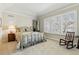 Bright bedroom features large window with shutters, neutral carpeting, and a rocking chair at 168 S Garfield St, Denver, CO 80209
