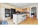 A kitchen showcasing maple cabinetry, black appliances, granite counters, and an island with seating at 168 S Garfield St, Denver, CO 80209