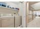 Laundry room with washer, dryer, shelves, and entrance to carpeted hallway and railing at 168 S Garfield St, Denver, CO 80209