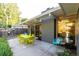 Inviting back patio featuring a lime green dining set, gray accent wall, and large glass windows at 1338 S Fairfax St, Denver, CO 80222