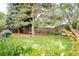 Serene backyard with mature trees, a cozy bench, and blooming flowers, providing a peaceful retreat at 1338 S Fairfax St, Denver, CO 80222