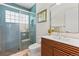 Sleek bathroom showcasing blue tile shower, glass door, and stylish vanity at 1338 S Fairfax St, Denver, CO 80222