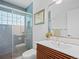 Bathroom featuring modern vanity, decor, large mirror, and glass walk-in shower with blue tiled walls at 1338 S Fairfax St, Denver, CO 80222
