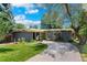 Charming single-story home with a well-manicured lawn, mature trees, and a curved driveway leading to the entrance at 1338 S Fairfax St, Denver, CO 80222