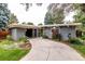 Well-maintained single-story home showcasing a curved driveway, lush lawn, and mature landscaping at 1338 S Fairfax St, Denver, CO 80222