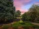 Beautiful single-story home featuring mature trees, lush lawn, and modern design elements at 1338 S Fairfax St, Denver, CO 80222