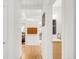Hallway with white walls, hardwood floors, and a view into the living room and bathroom at 1338 S Fairfax St, Denver, CO 80222