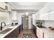 Modern kitchen featuring stainless steel appliances, sleek white cabinets, and stone countertops at 1338 S Fairfax St, Denver, CO 80222